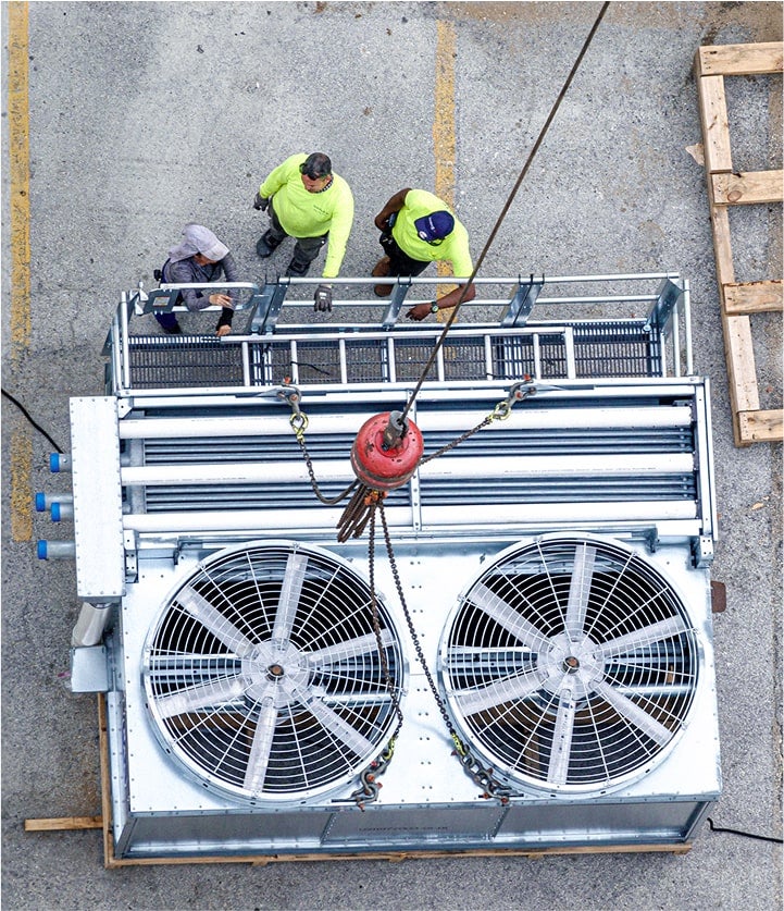 group of workers working on a large HVAC machine outdoors